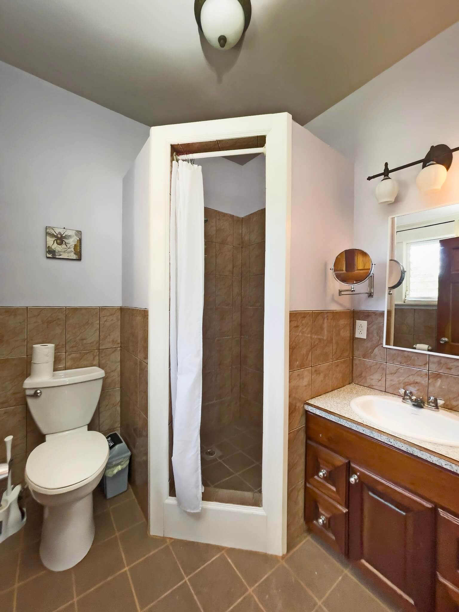 Small bathroom with shower, toilet, and sink.