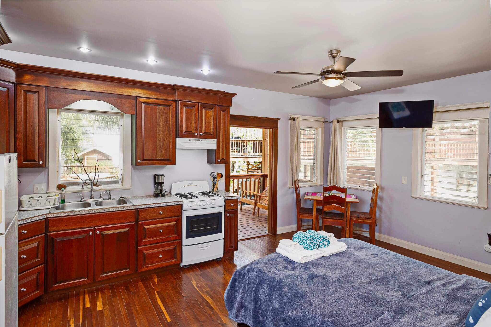 Cozy kitchen with wooden cabinets and bed.