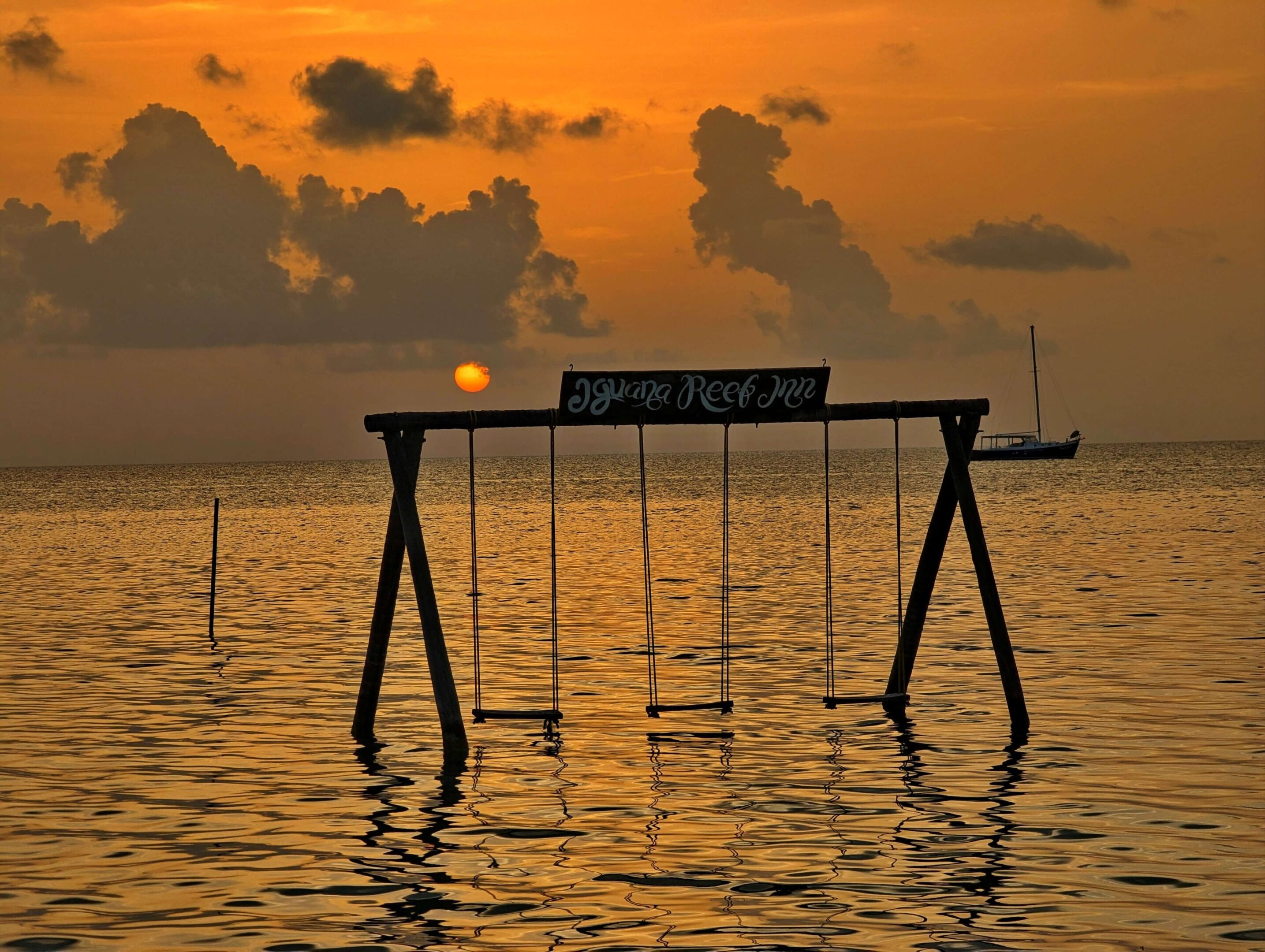 Sunset over swings in the ocean.