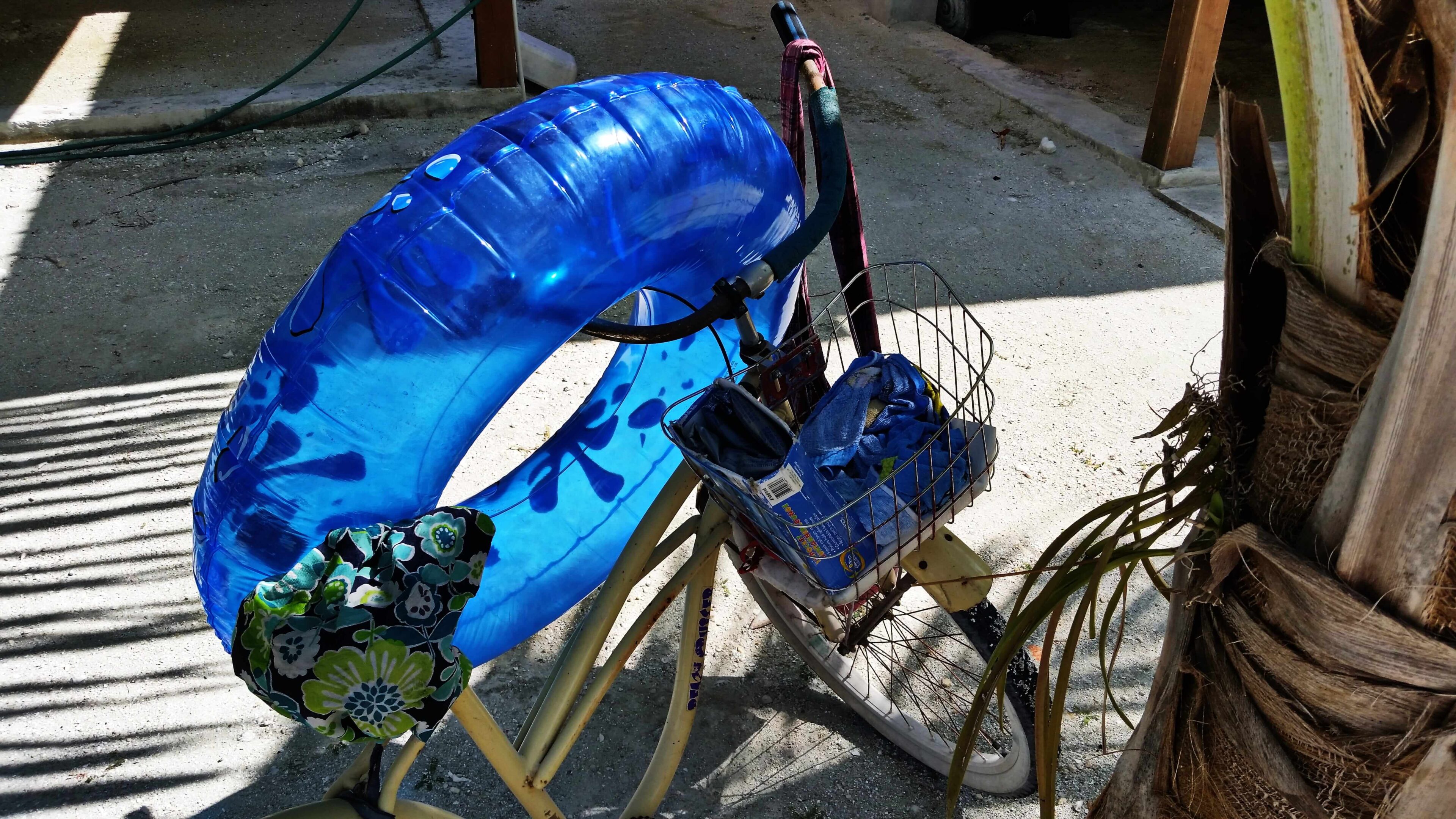 Bicycle with blue float and basket items.